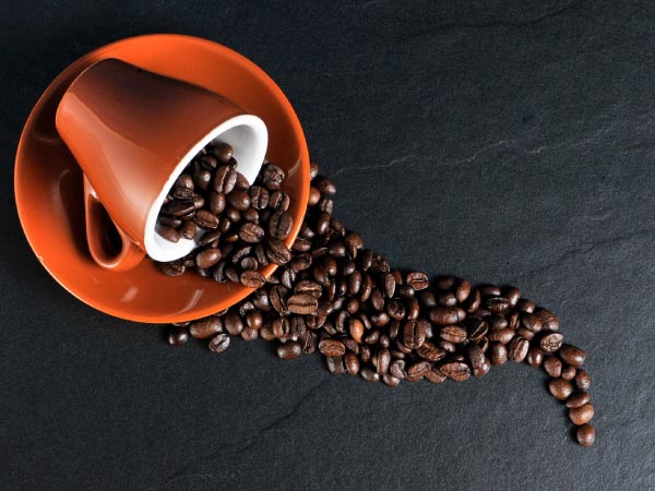 コーヒーカップからこぼれるコーヒー豆