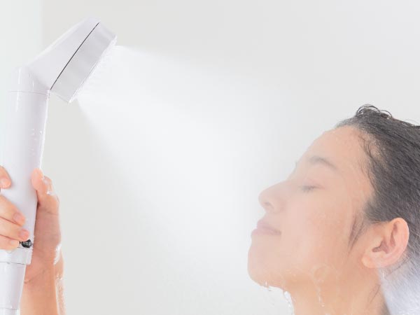 シャワーを顔に浴びる女性